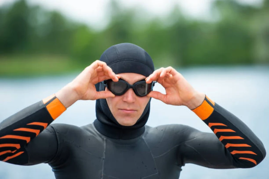Man wearing neoprene swimming cap with wetsuit in water