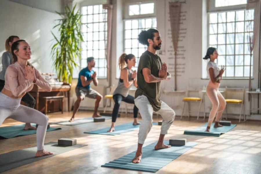 Men and women in class with yoga blocks on mats