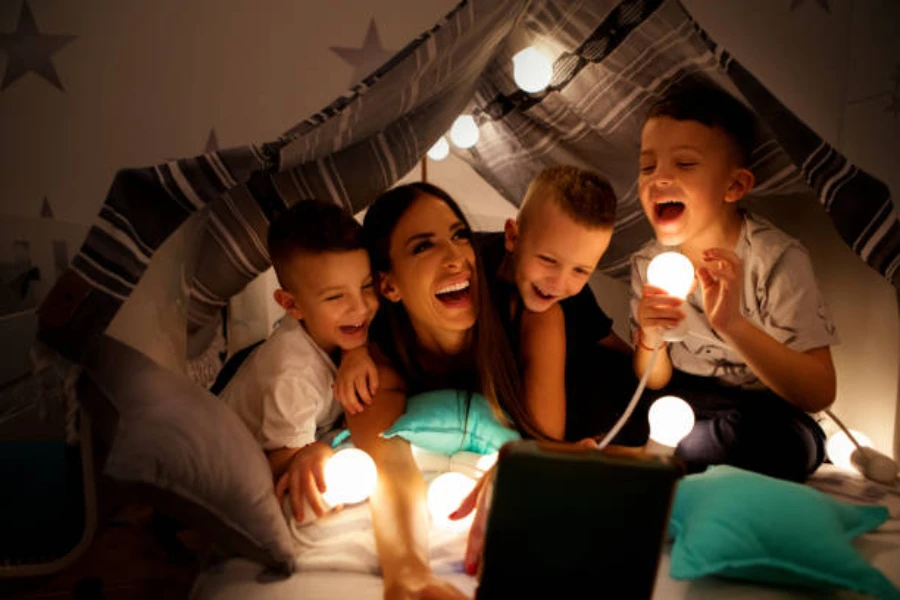 Mother and three children in tent with LED camping lights