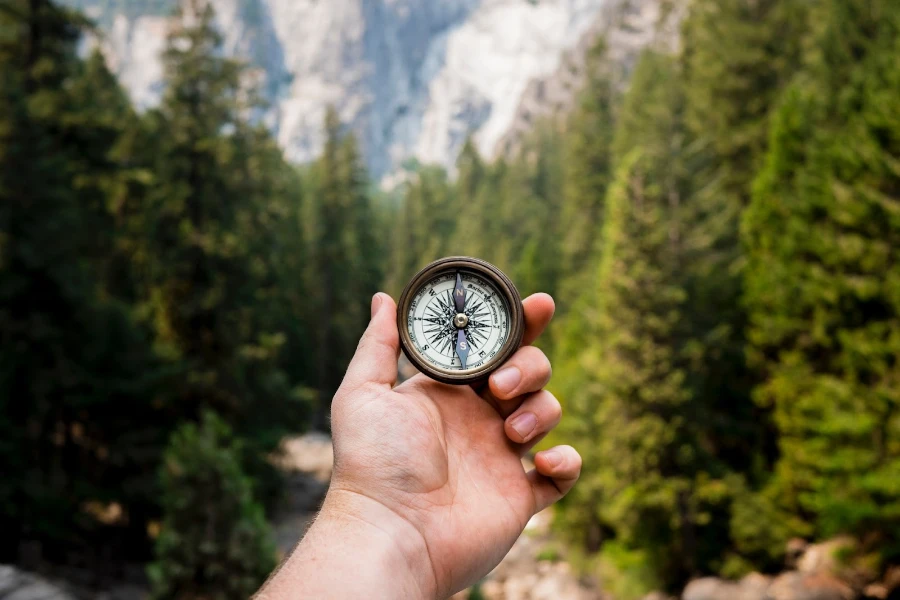 Person holding an old school compass out in the wilderness