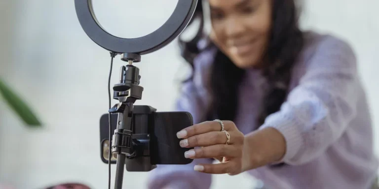 Person starting to take a video with smartphone in a ring light