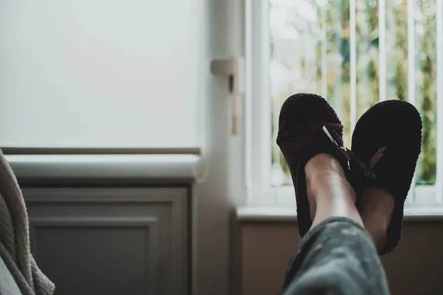 Person wearing a pair of stylish black slides