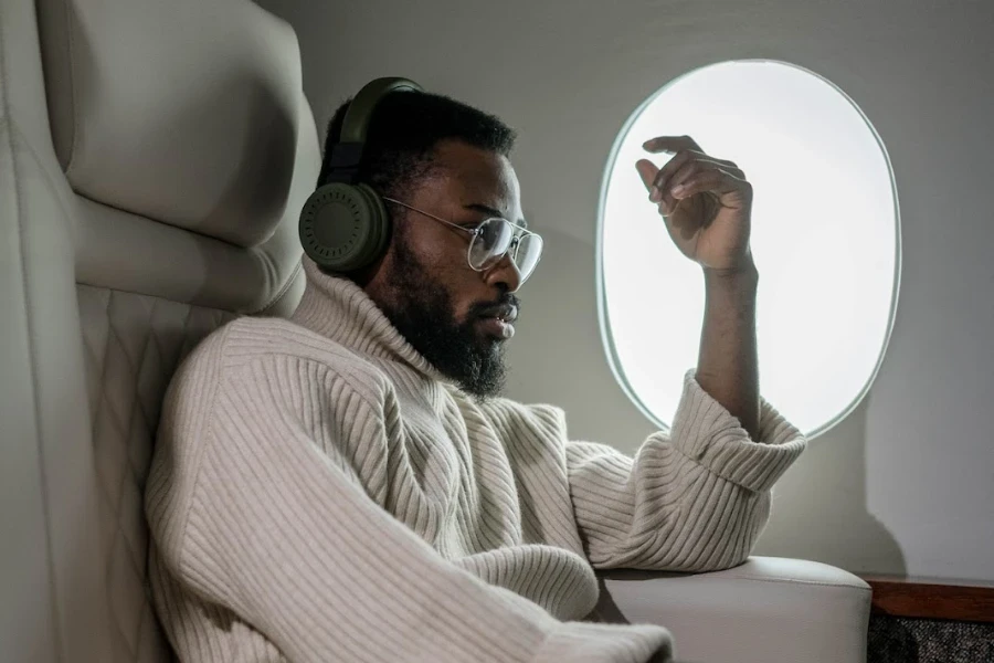 Person wearing over-ear headphones on an airplane