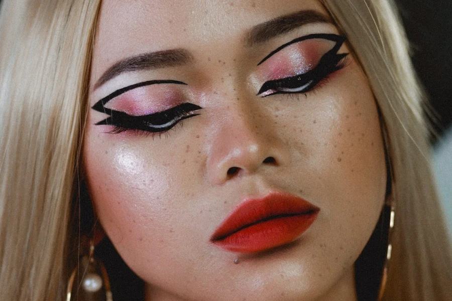 Person with cat eye eyeliner and bold red lips
