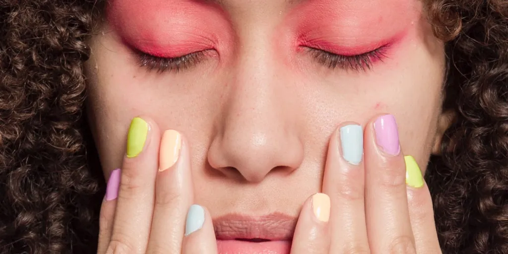 Person with pink eyeshadow and pastel fingernails