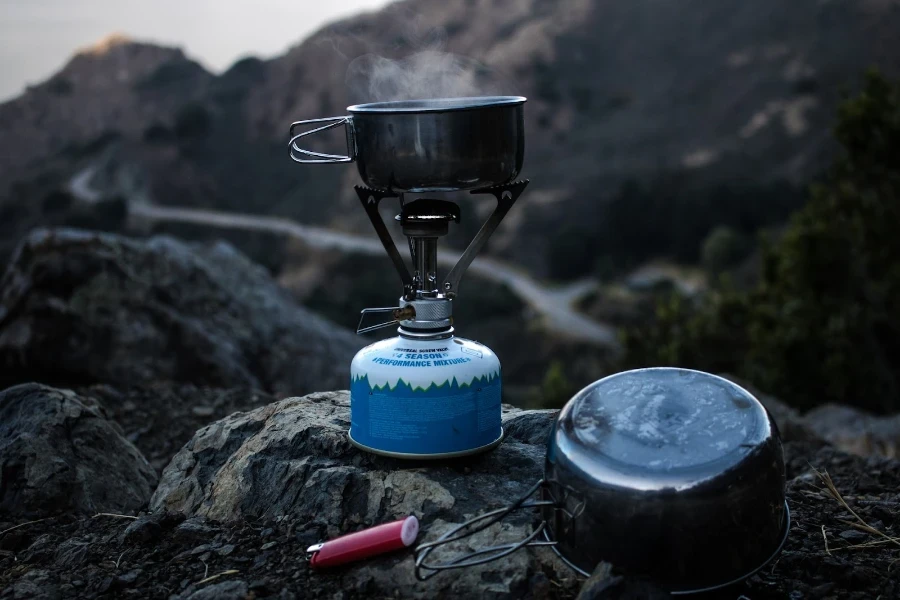 Estufa portátil calentando una olla en la cima de una montaña