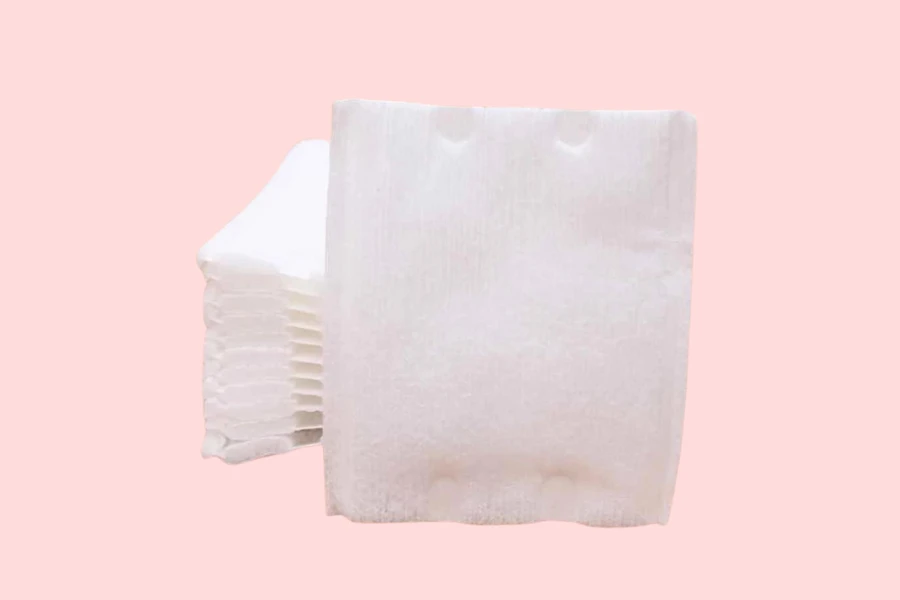 Pressed edge cotton pads against pink background