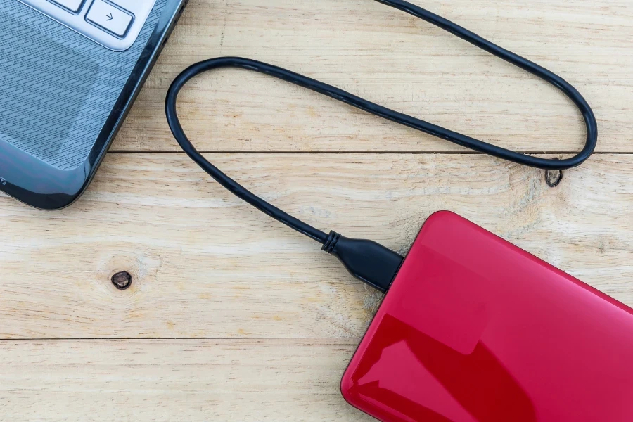 Disco duro rojo conectado a una computadora portátil azul