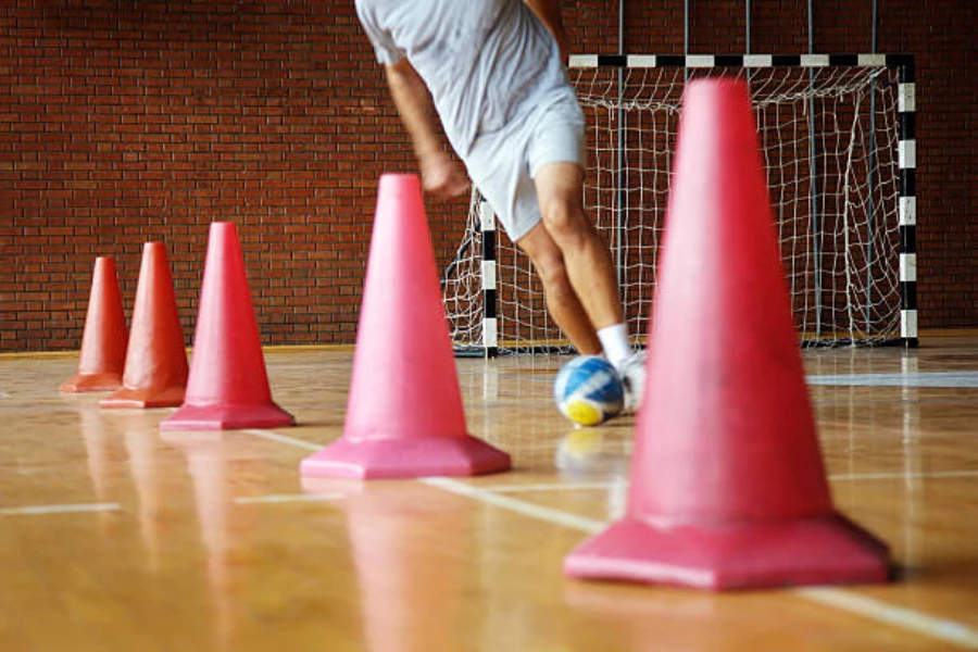 Red pylon cones being used inside gym for soccer