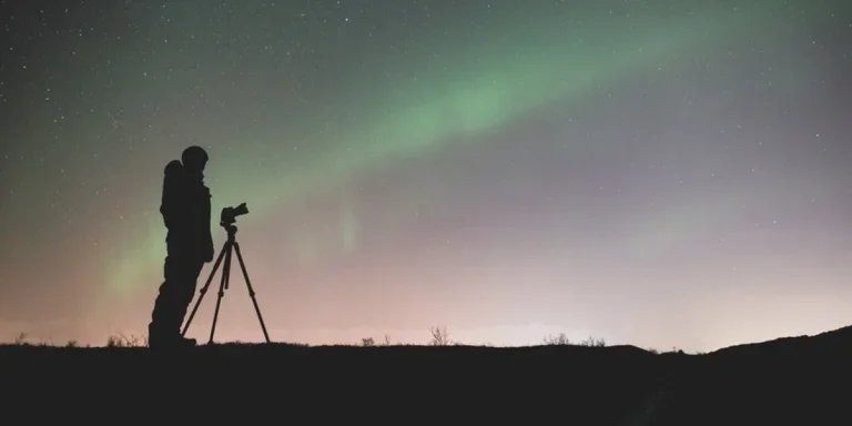 Silhouette of a man with a camera on a tripod