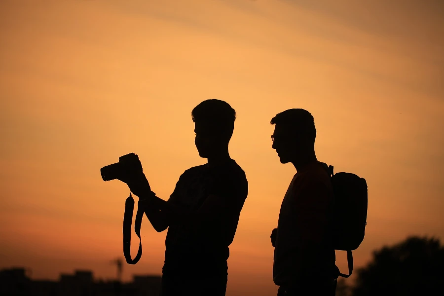 Silhouette of men shooting with a camera outdoors