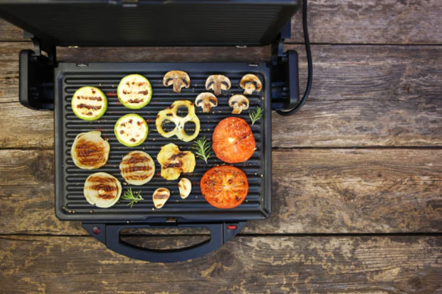 smokeless electric grill being used to grill vegetables on table