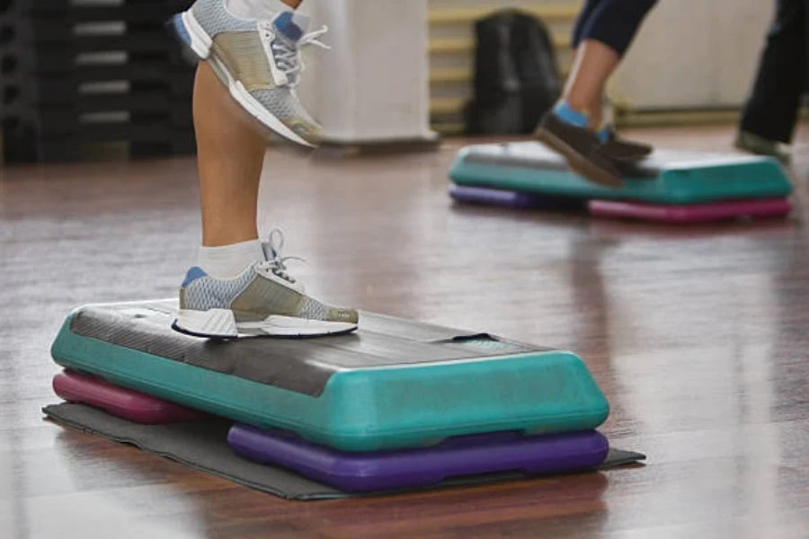 Plataforma de ejercicios con escalones y ajustadores de altura utilizada en clases de fitness