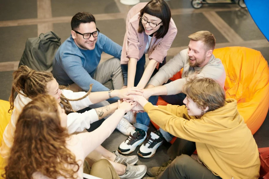 Team members stand their hands together, signifying a strong relationship