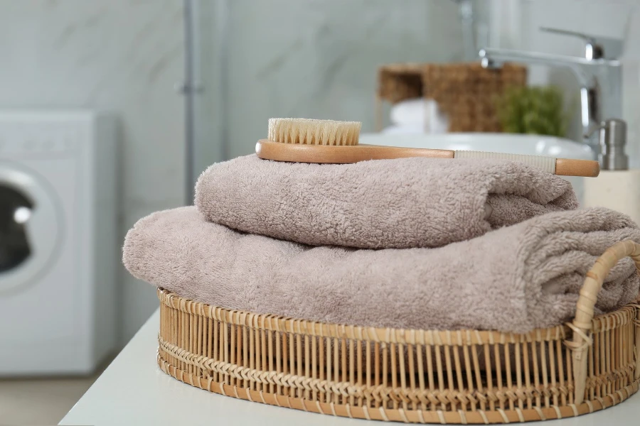 towels and a brush in a wicker basket on a bathroom counter