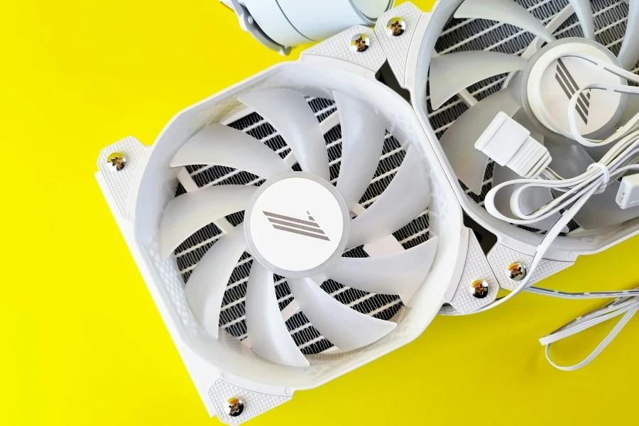 Dois ventiladores brancos sobre um fundo amarelo