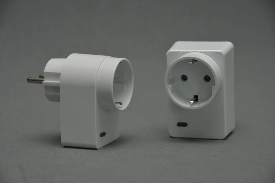 Two white smart plugs on a gray background