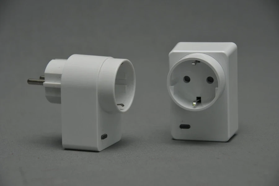 Two white smart plugs on a gray background