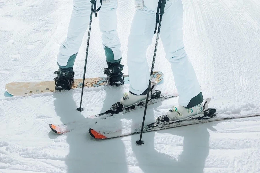 Dos mujeres esquiando y una tabla de snowboard.