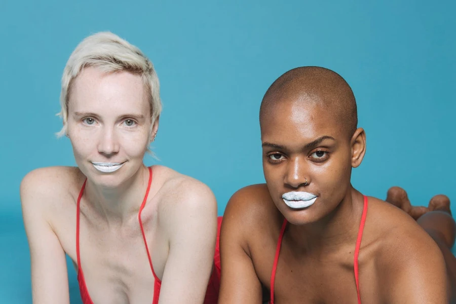 Two women with different skin tones wearing white lipstick