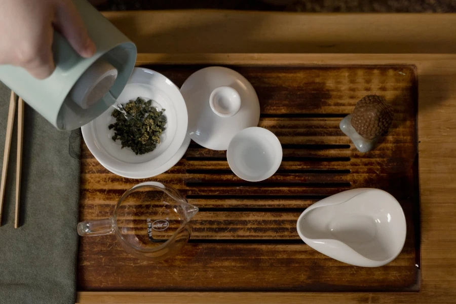 Juego de té de cerámica blanca sobre una tabla de madera