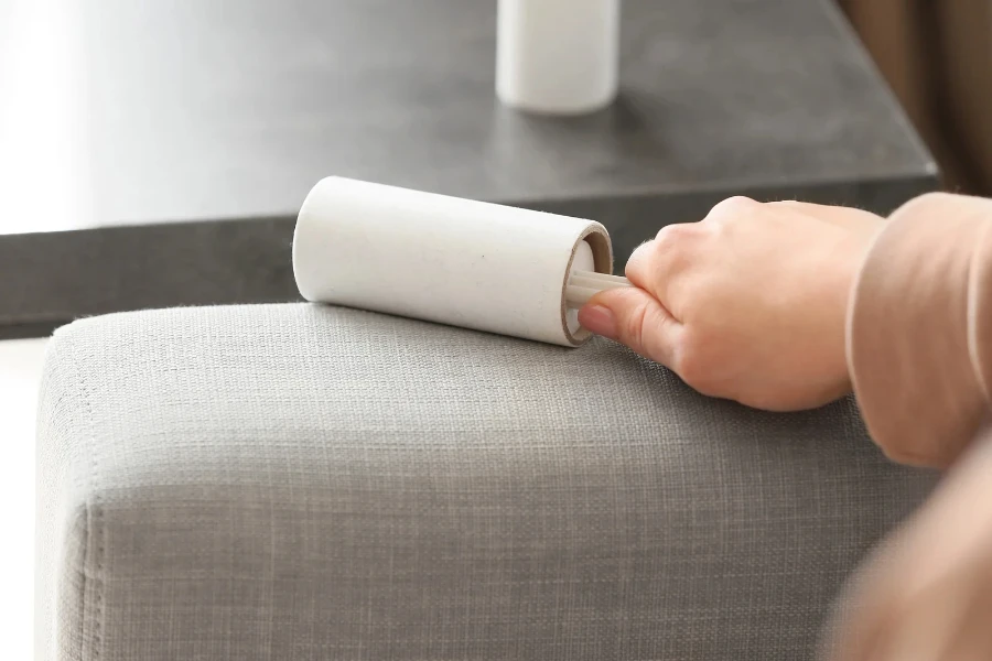 Woman cleaning sofa with lint rollers