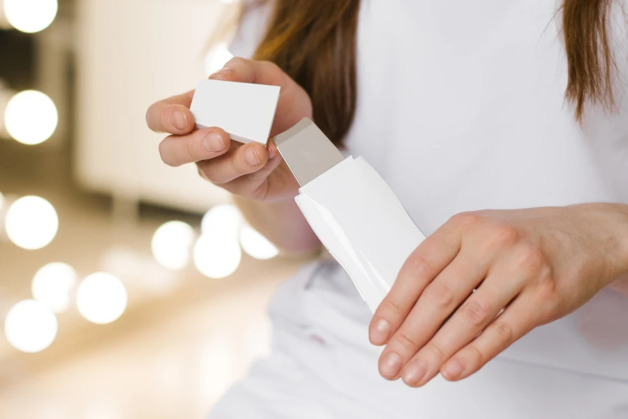 Woman holding a white wireless ultrasonic skin scrubber