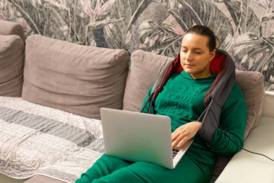 Woman relaxing on couch wearing electric neck massager