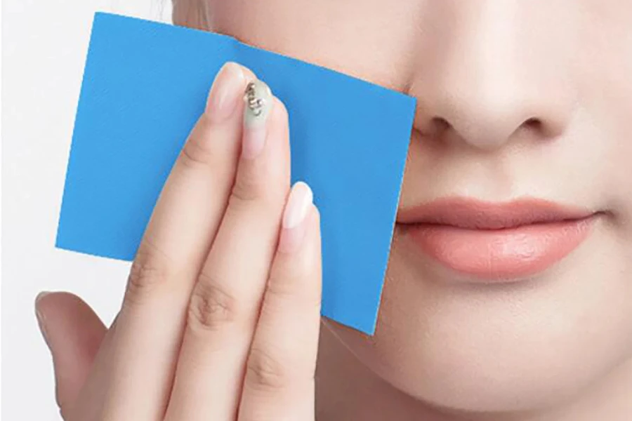 Woman using a sheet of blue blotting paper