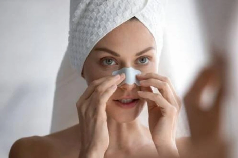 Woman with a towel on her head applying nose strip