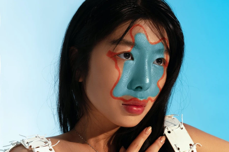 Women with blue and orange splatter painted on the middle of her face