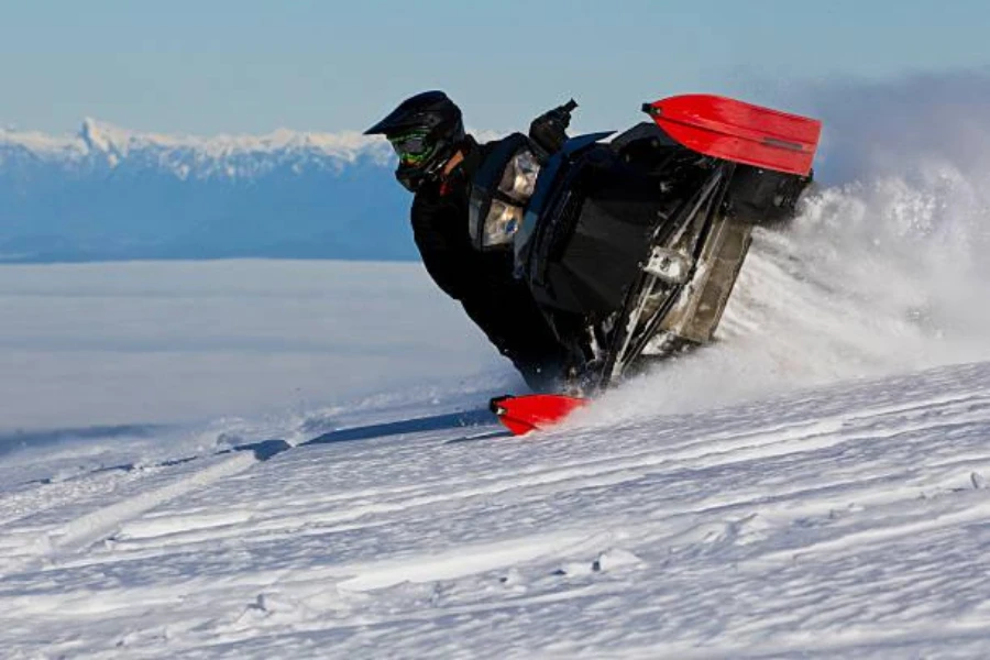 Young man drifting while riding a performance snowmobile