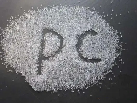 Granules de polycarbonate (PC) disposés en forme de lettres « PC » sur une surface sombre