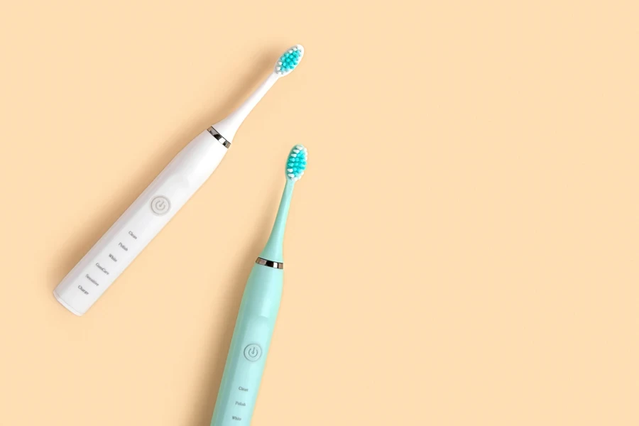 Two electric toothbrushes on beige background