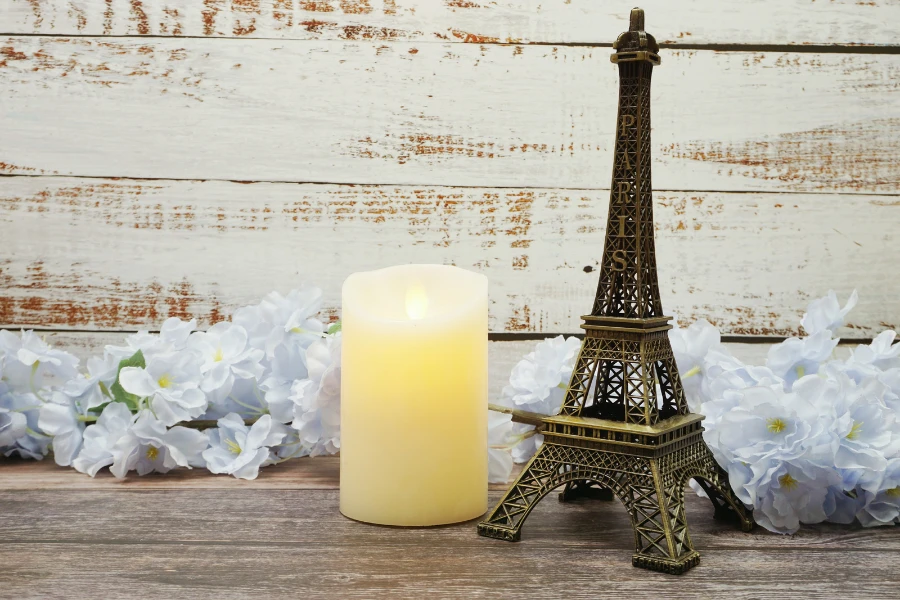 A flameless candle and an Eiffel tower on a wooden background