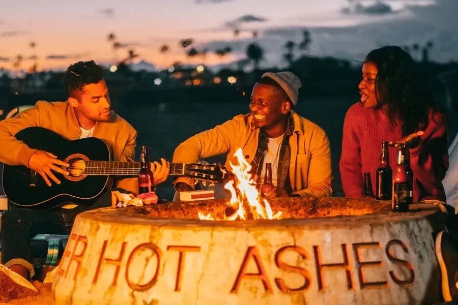 A group of friends surrounding an outdoor fire pit