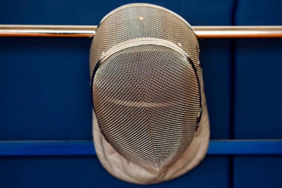 A hanging silver fencing mask