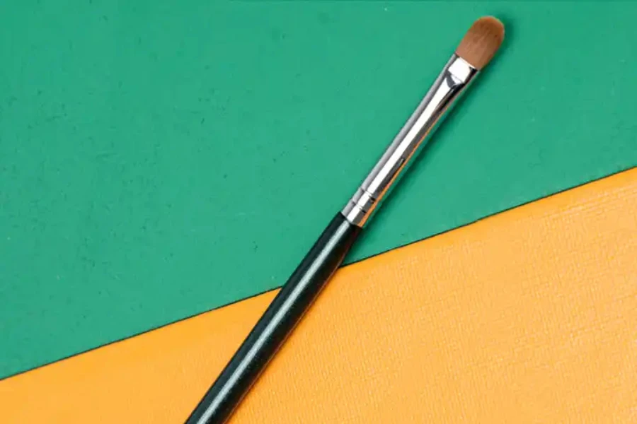 A single eyeshadow brush on a multicolored background