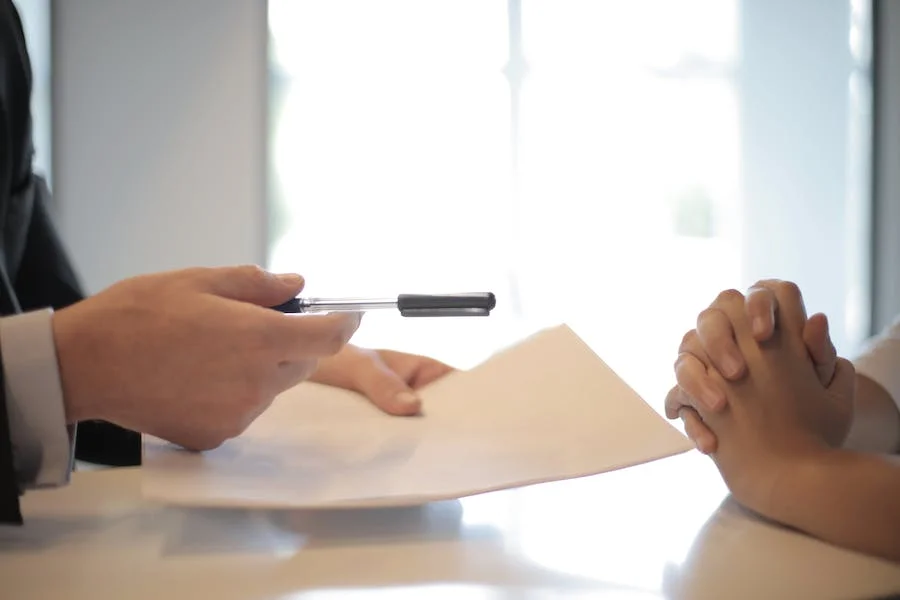 Businessman giving a contract to a woman to sign it