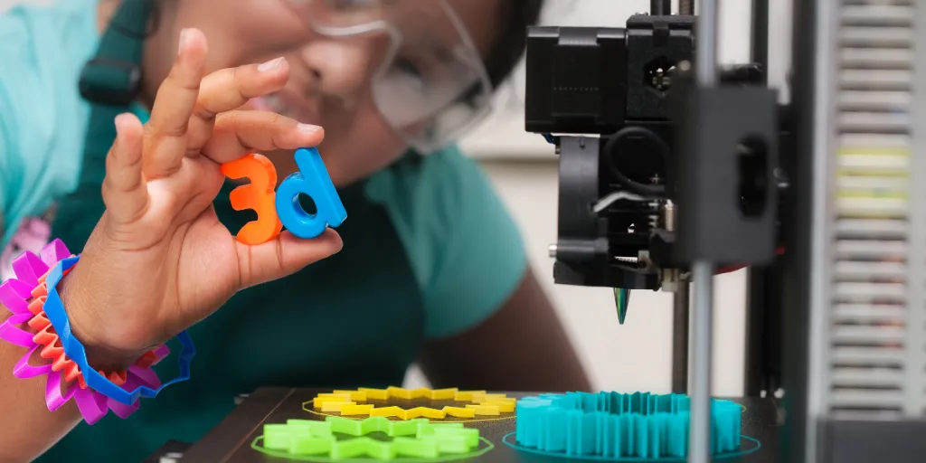 Child with safety glasses using a 3D printer