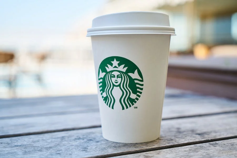 Geschlossener weißer und grüner Starbucks-Einwegbecher