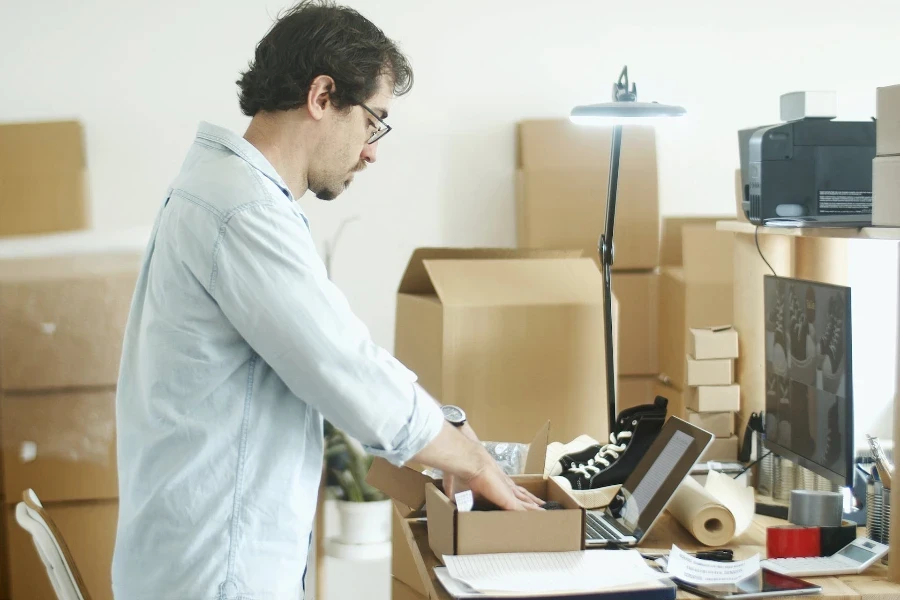 Vendeurs de commerce électronique emballant une boîte en carton