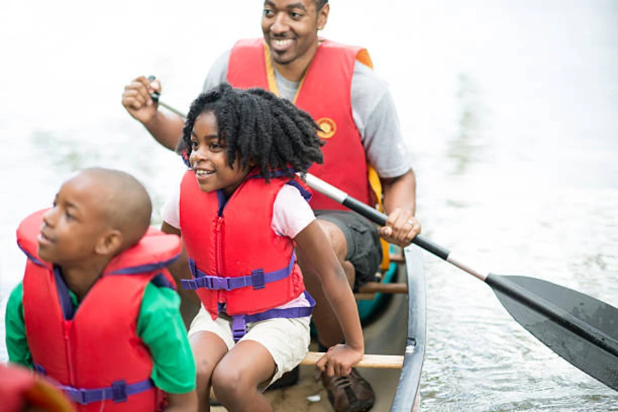 Family in canoe and wearing red and purple life jackets