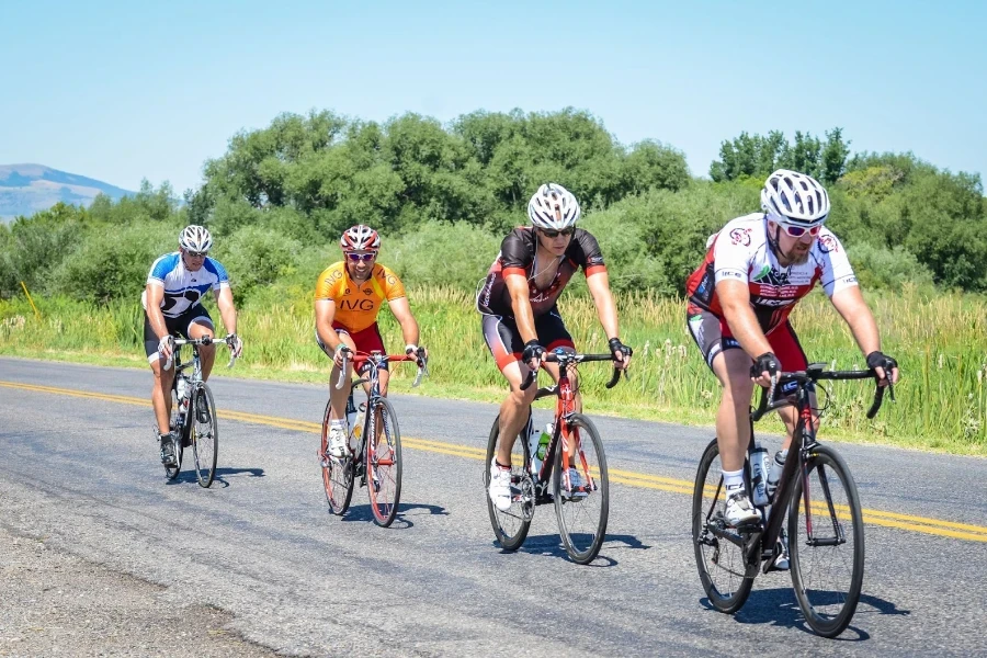 Quatre cyclistes sur une route en campagne