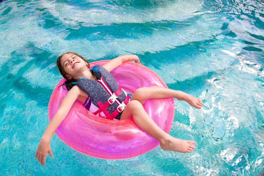 Menina usando anel de donut flutuante enquanto usava colete salva-vidas floral