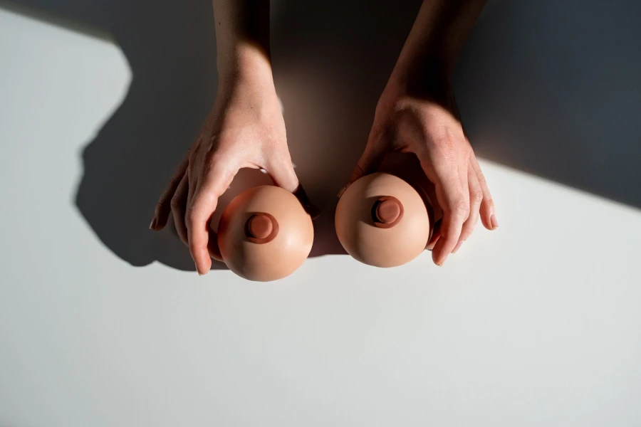 Mãos segurando duas formas de peito