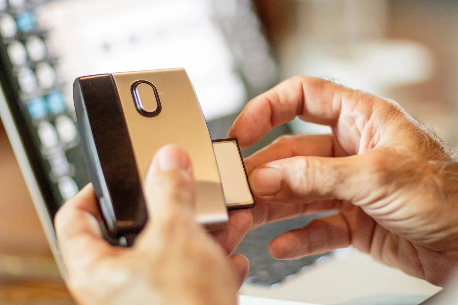 Hands inserting card into a black and gold card reader