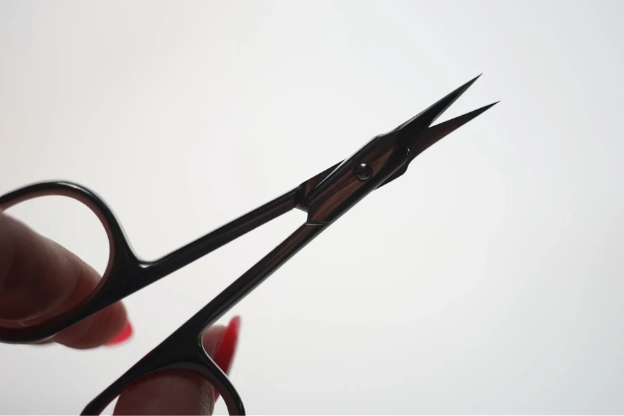 Lady holding black steel manicure scissors