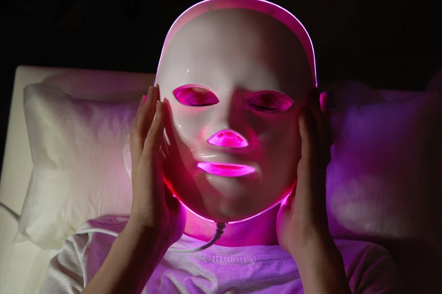 Senhora removendo uma máscara facial LED branca