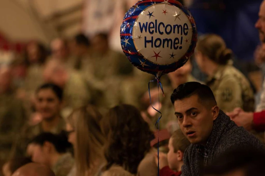 Man holding a welcome home balloon
